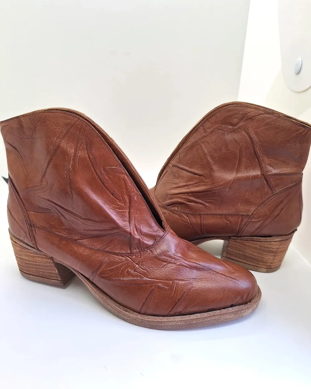 Par de botinetas de cuero marrón con textura curtida y taco bajo de madera